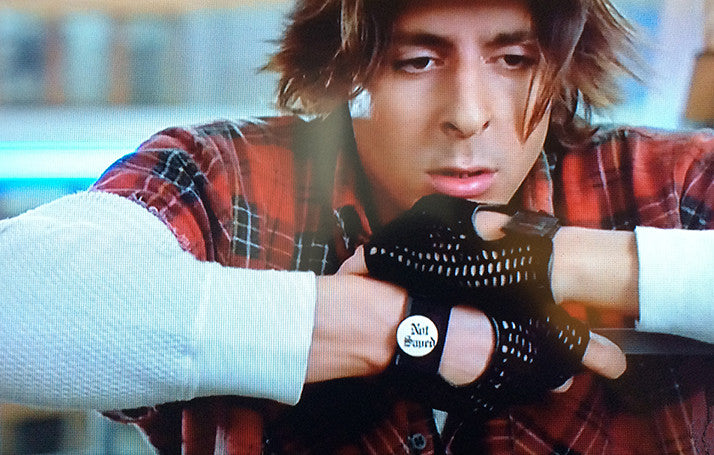 Movie still showing Judd Nelson's character with Not Saved pin back button on black mesh half gloves